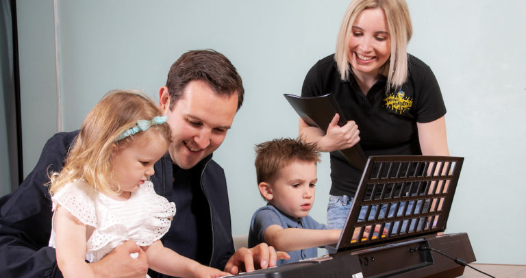 Music Monsters Solihull. Children and father playing piano together